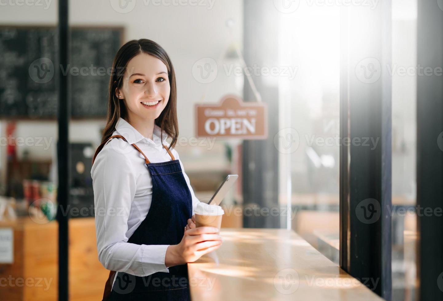 opstarten geslaagd klein bedrijf eigenaar mkb vrouw staan met tablet in cafe restaurant. foto