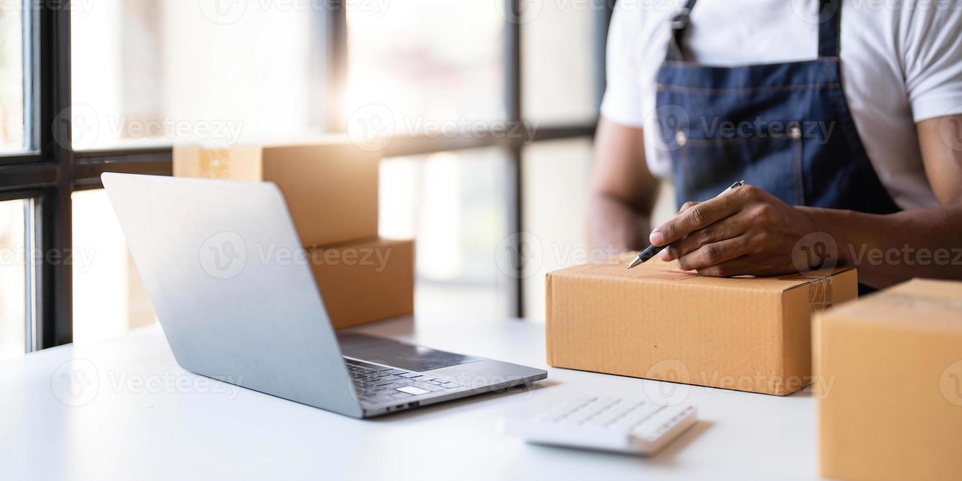 beginnend klein ondernemingen mkb eigenaren mannetje ondernemers schrijven de adres Aan bon doos en controleren online bestellingen naar bereiden naar pak de dozen, verkopen naar klanten, mkb bedrijf ideeën online. foto