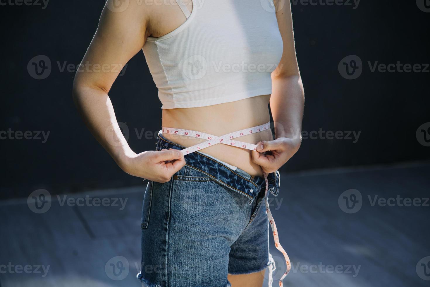 dik vrouw, dik buik, mollig, zwaarlijvig vrouw hand- Holding buitensporig buik dik met meten plakband, vrouw eetpatroon levensstijl concept foto