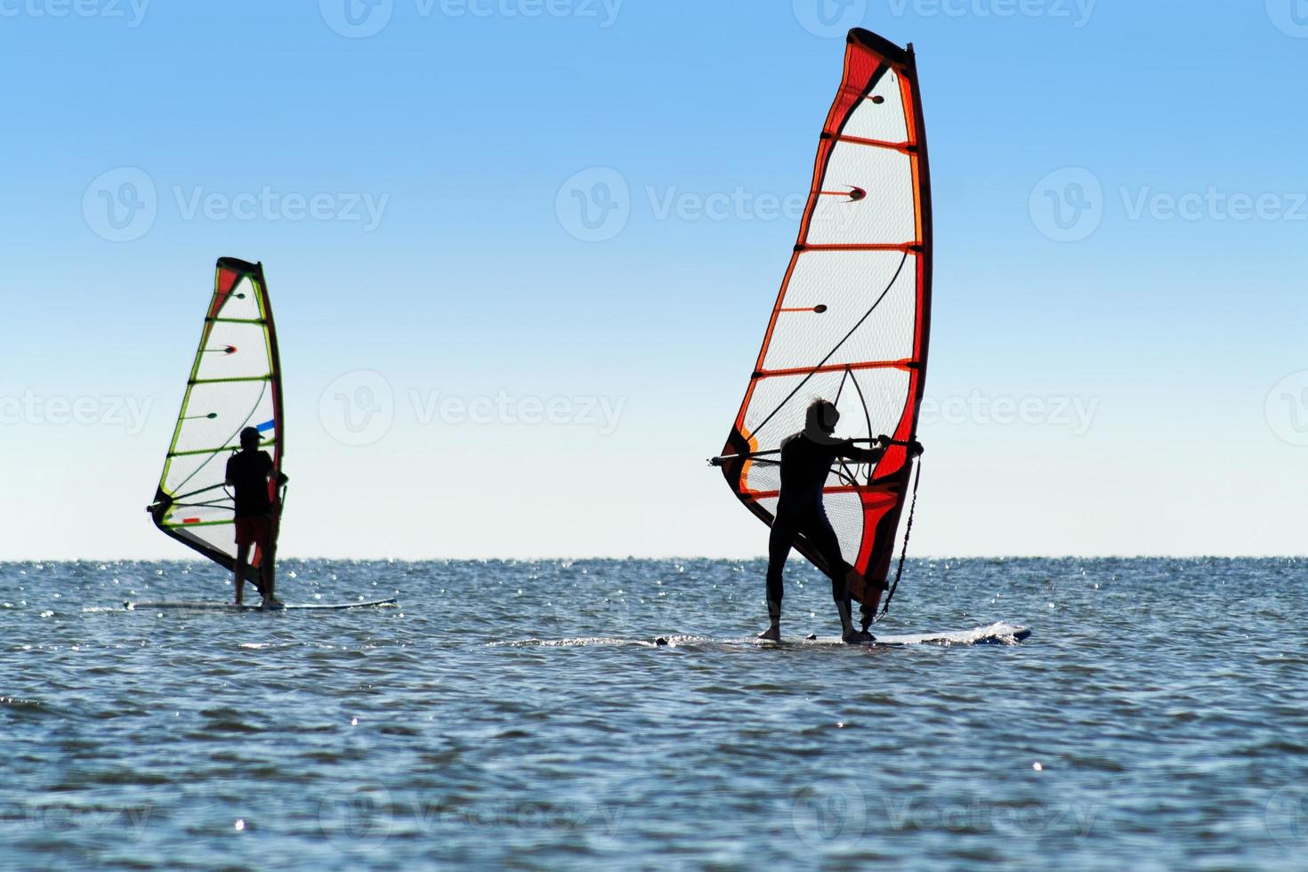 silhouet van een twee windsurfers foto