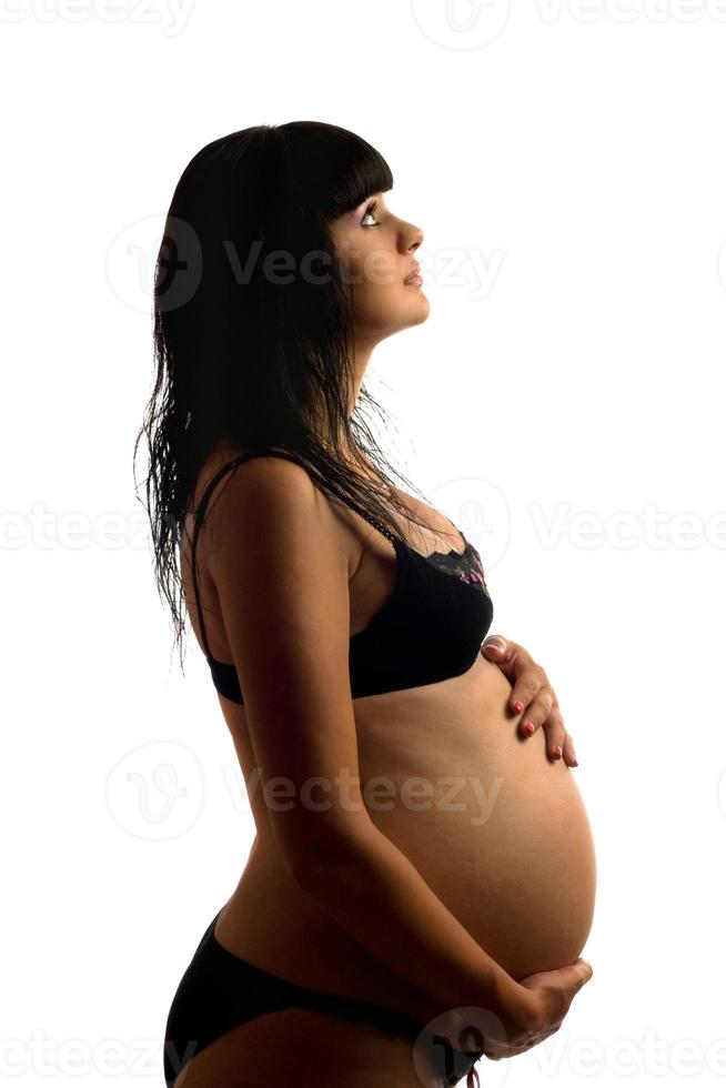 zwanger jong brunette in zwart lingerie foto