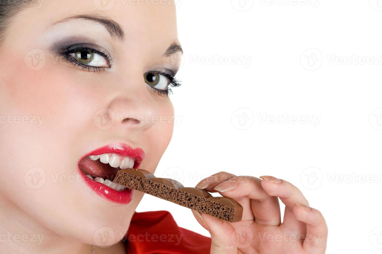 portret van de mooi jong vrouw aan het eten chocola foto