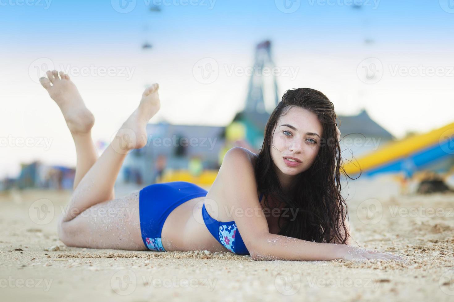 jong brunette poseren Aan de zand foto