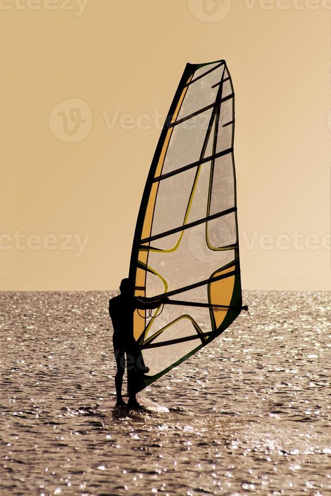 silhouet van een windsurfer Aan golven foto