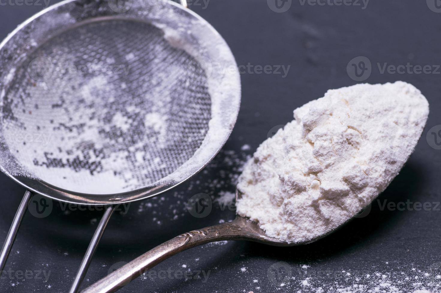 wit tarwe meel in een ijzer lepel foto
