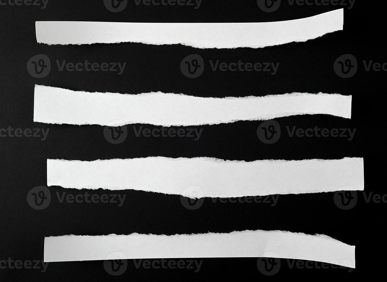gescheurd blanco wit papier stroken tegen een zwart achtergrond foto
