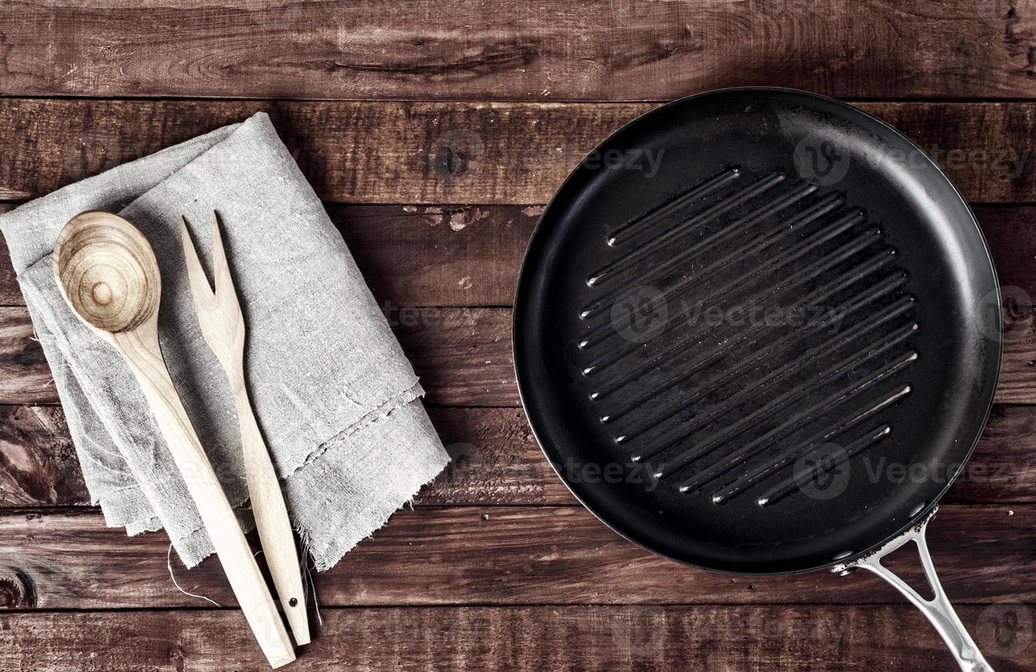 leeg rooster pan met houten spatel en lepel foto