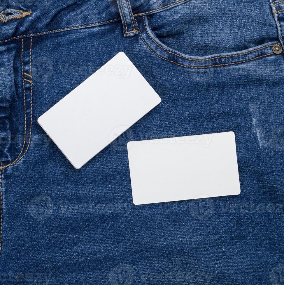 blanco wit papier bedrijf kaarten Aan een blauw jeans achtergrond foto