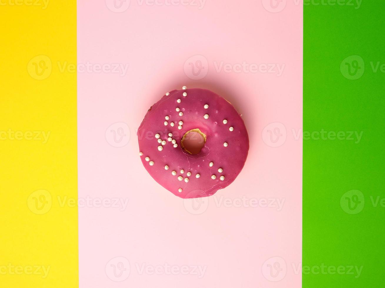 geheel ronde rood donut met hagelslag liggen Aan een kleur achtergrond foto