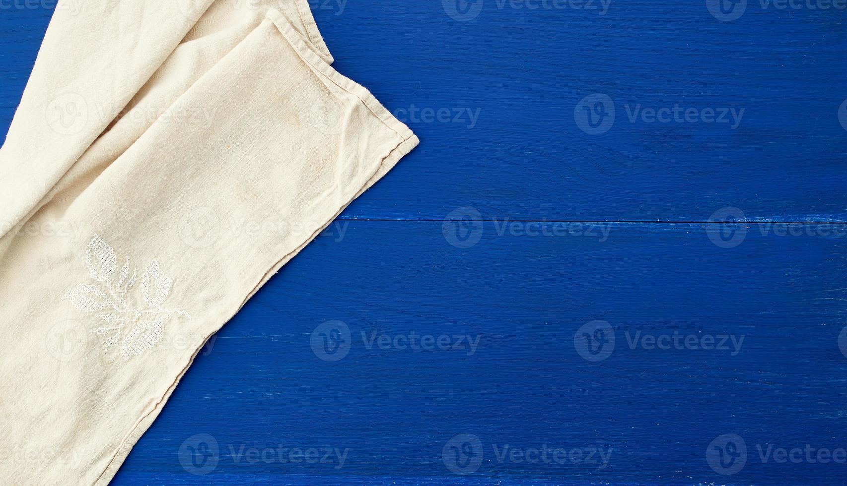 wit keuken textiel handdoek gevouwen Aan een blauw houten tafel van oud borden foto