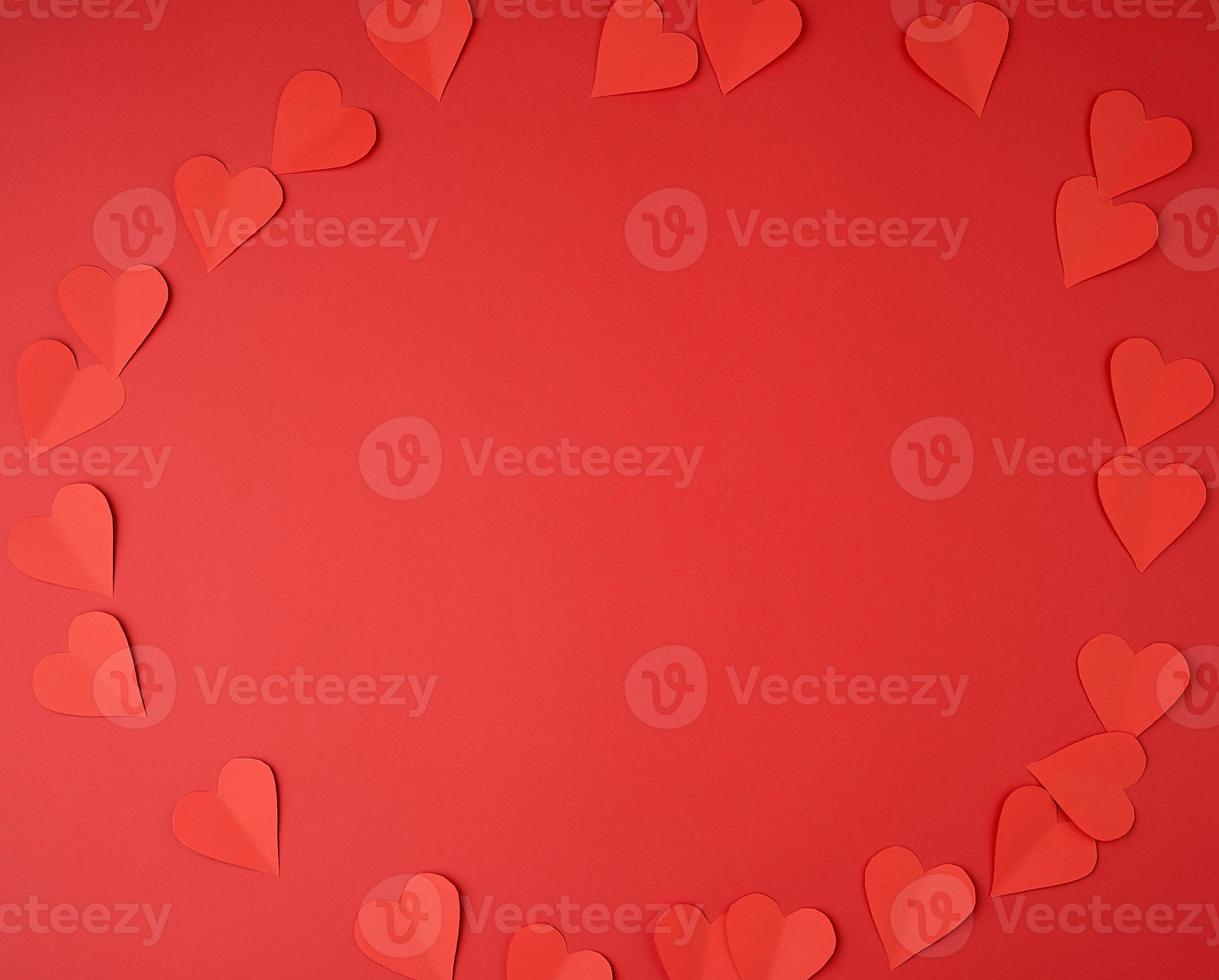 harten besnoeiing uit van rood papier Aan een rood achtergrond, feestelijk backdrop voor Valentijnsdag dag foto