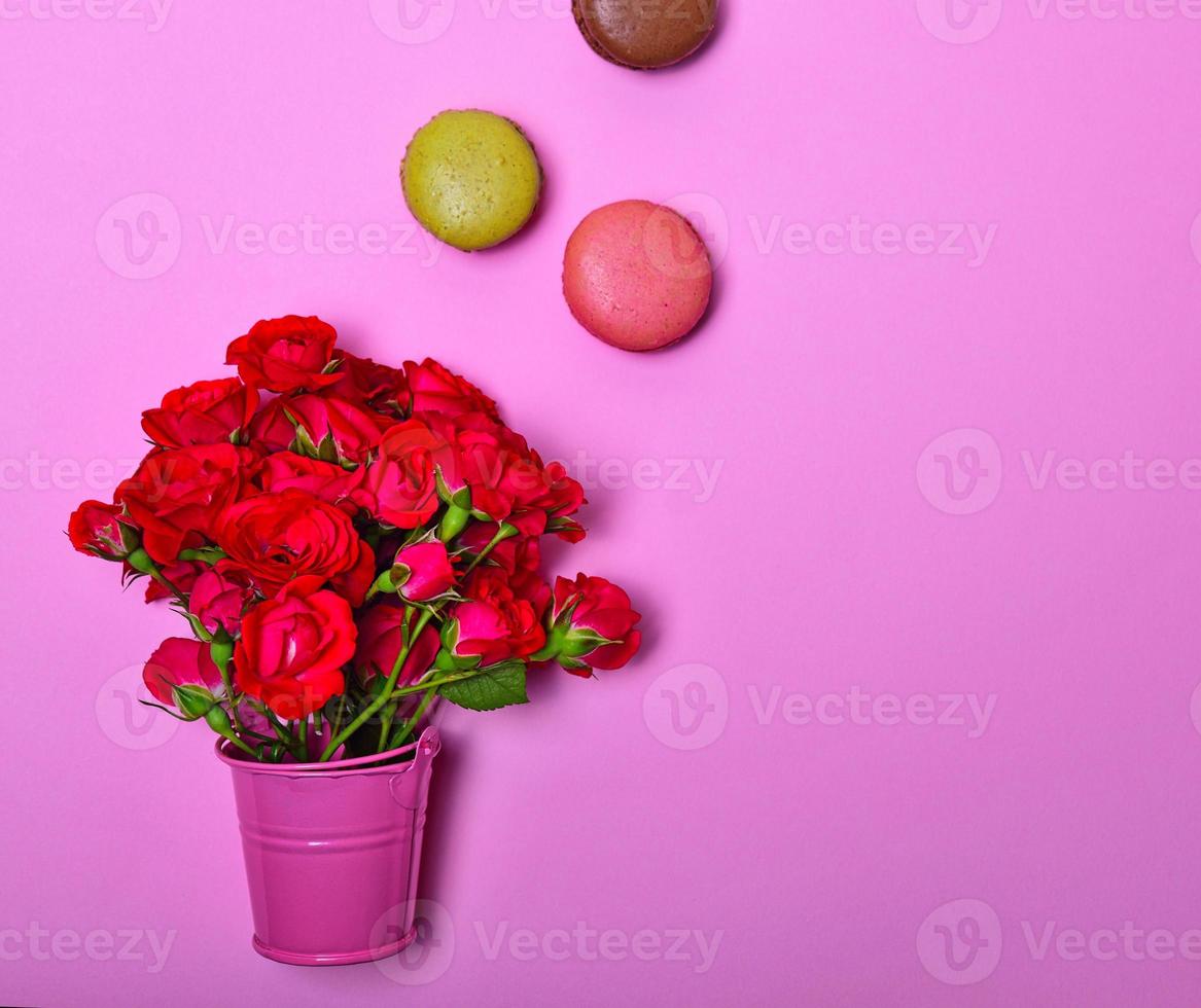 boeket van roze rozen en veelkleurig bitterkoekjes foto