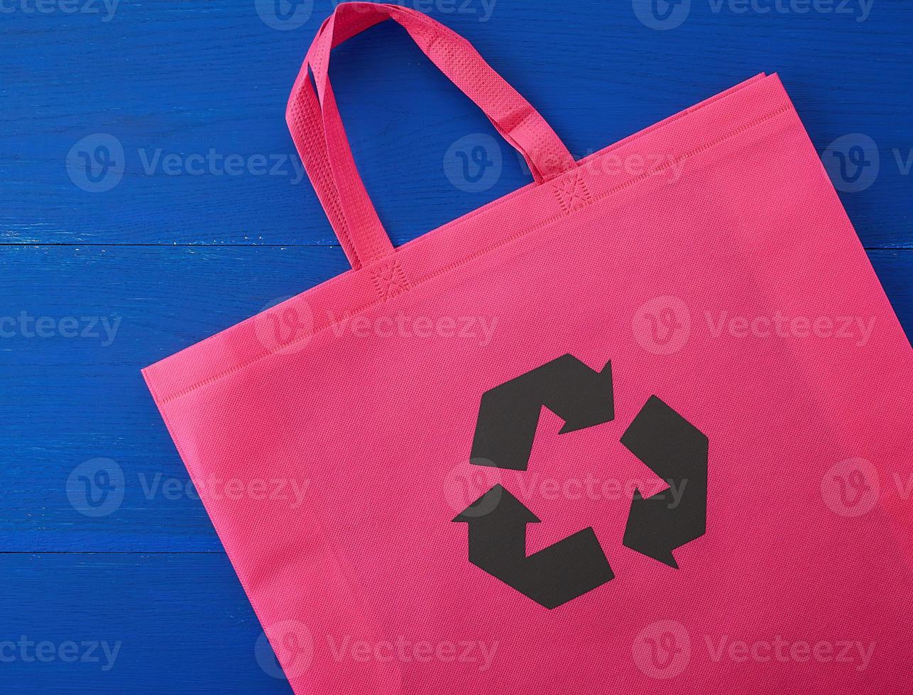 herbruikbaar roze viscose zak Aan blauw houten achtergrond foto