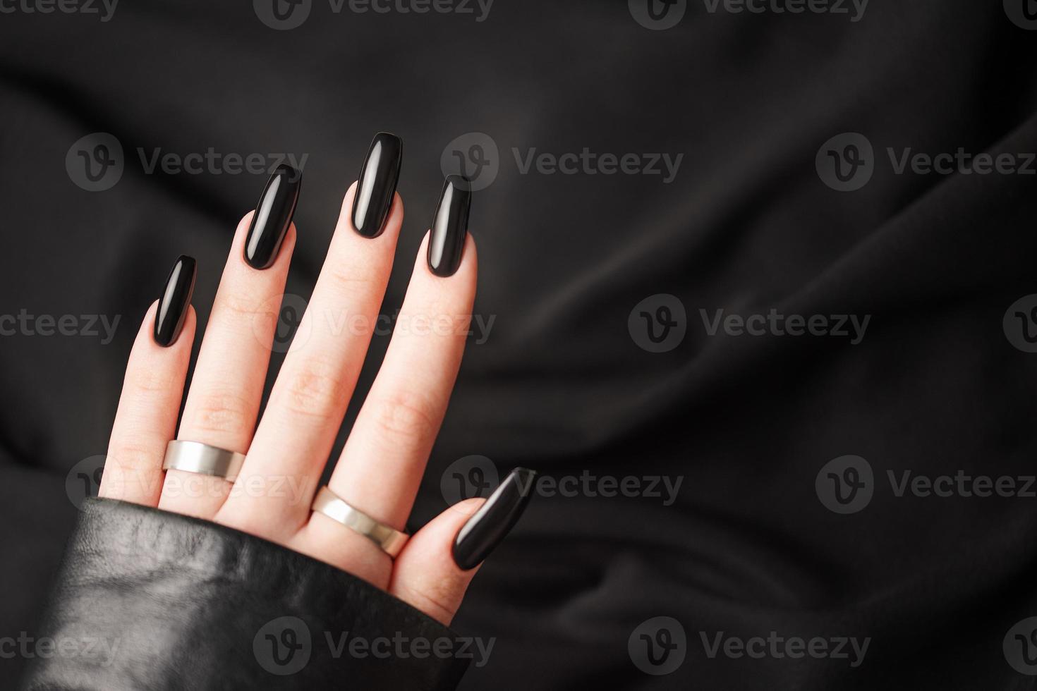 handen van een jong meisje met zwart manicure Aan nagels foto