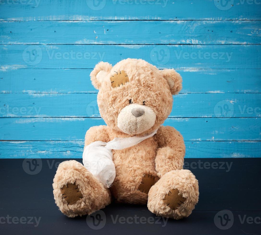 bruin teddy beer met teruggespoeld wit verband poot foto