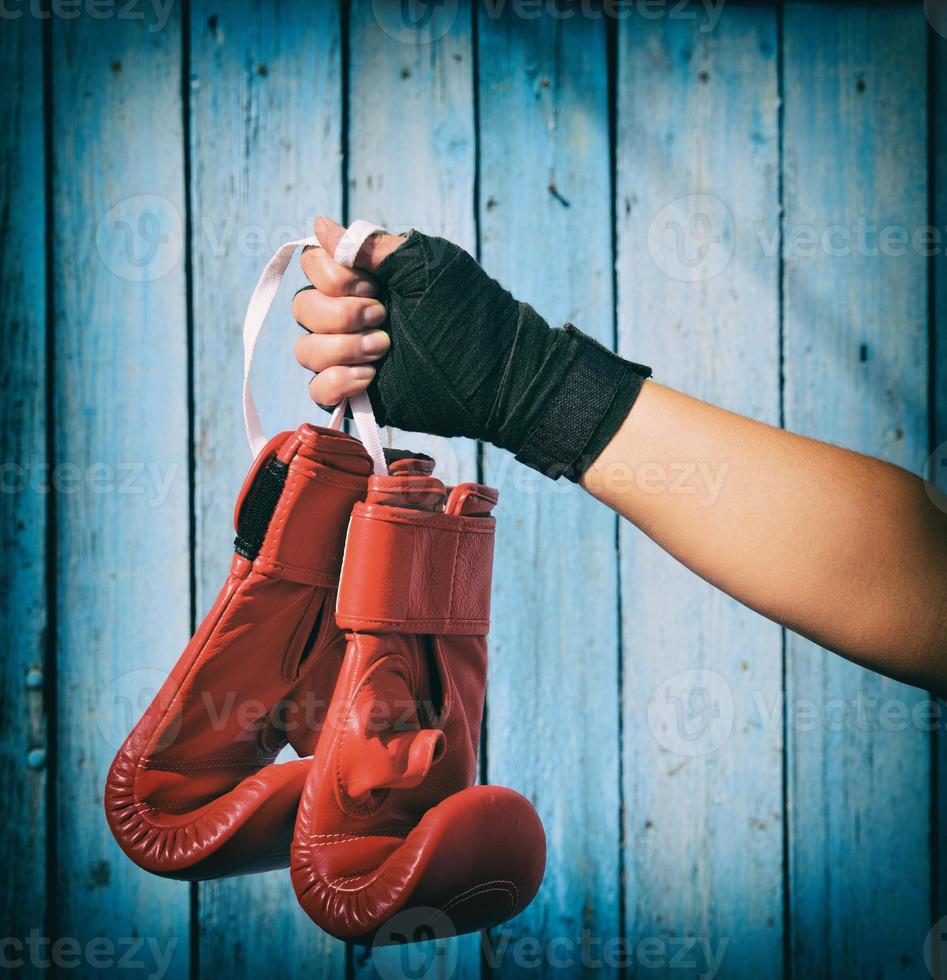 vrouw hand- houdt een paar- van rood kickboksen handschoenen foto