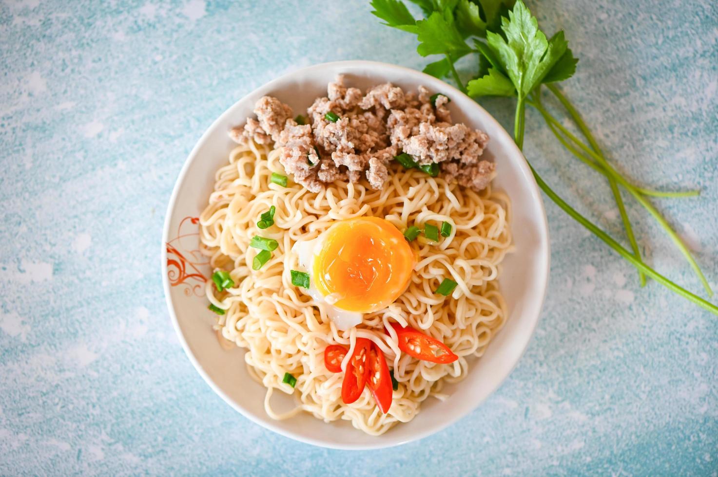 noedels bord met ei fijngehakt varkensvlees groente voorjaar ui selderij en Chili Aan tafel voedsel , ogenblik noedels Koken smakelijk aan het eten met kom noodle soep foto