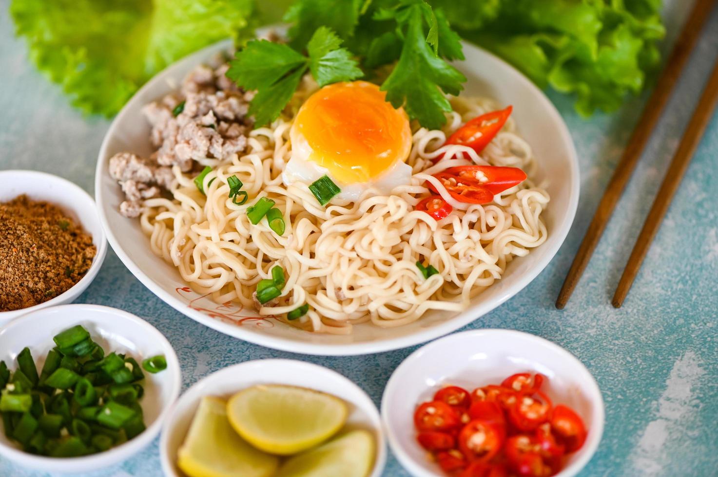 noedels bord met ei fijngehakt varkensvlees groente voorjaar ui citroen limoen sla selderij en Chili Aan tafel voedsel , ogenblik noedels Koken smakelijk aan het eten met kom noodle soep foto