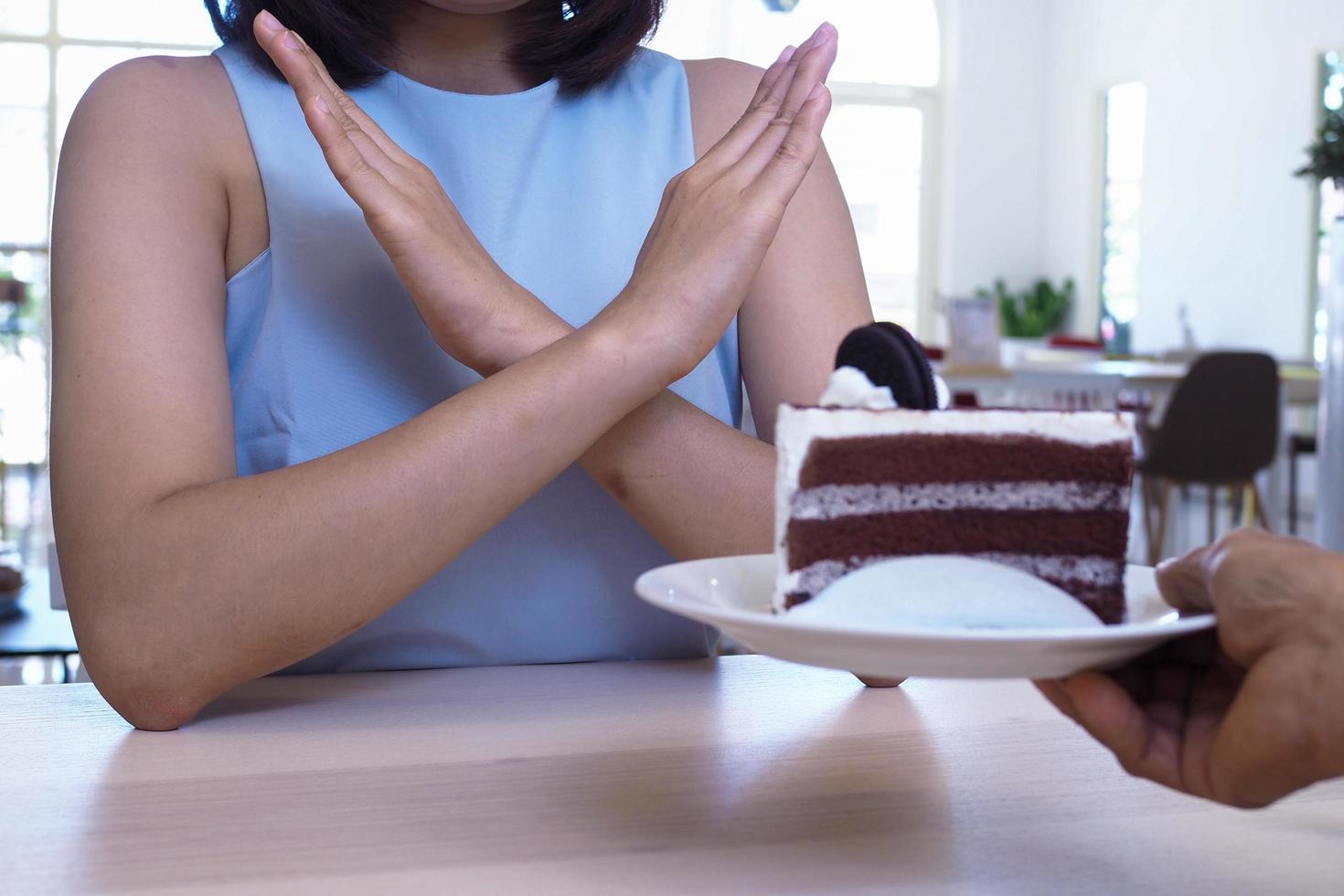 meisjes gebruikt een hand- naar Duwen een bord van chocola taart foto