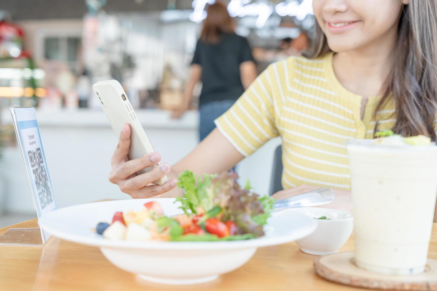 vrouw gebruik smartphone naar scannen qr code naar betalen in cafe restaurant met een digitaal betaling zonder contant geld. Kiezen menu en bestellen accumuleren korting. e portemonnee, technologie, betalen online, credit kaart, bank app foto