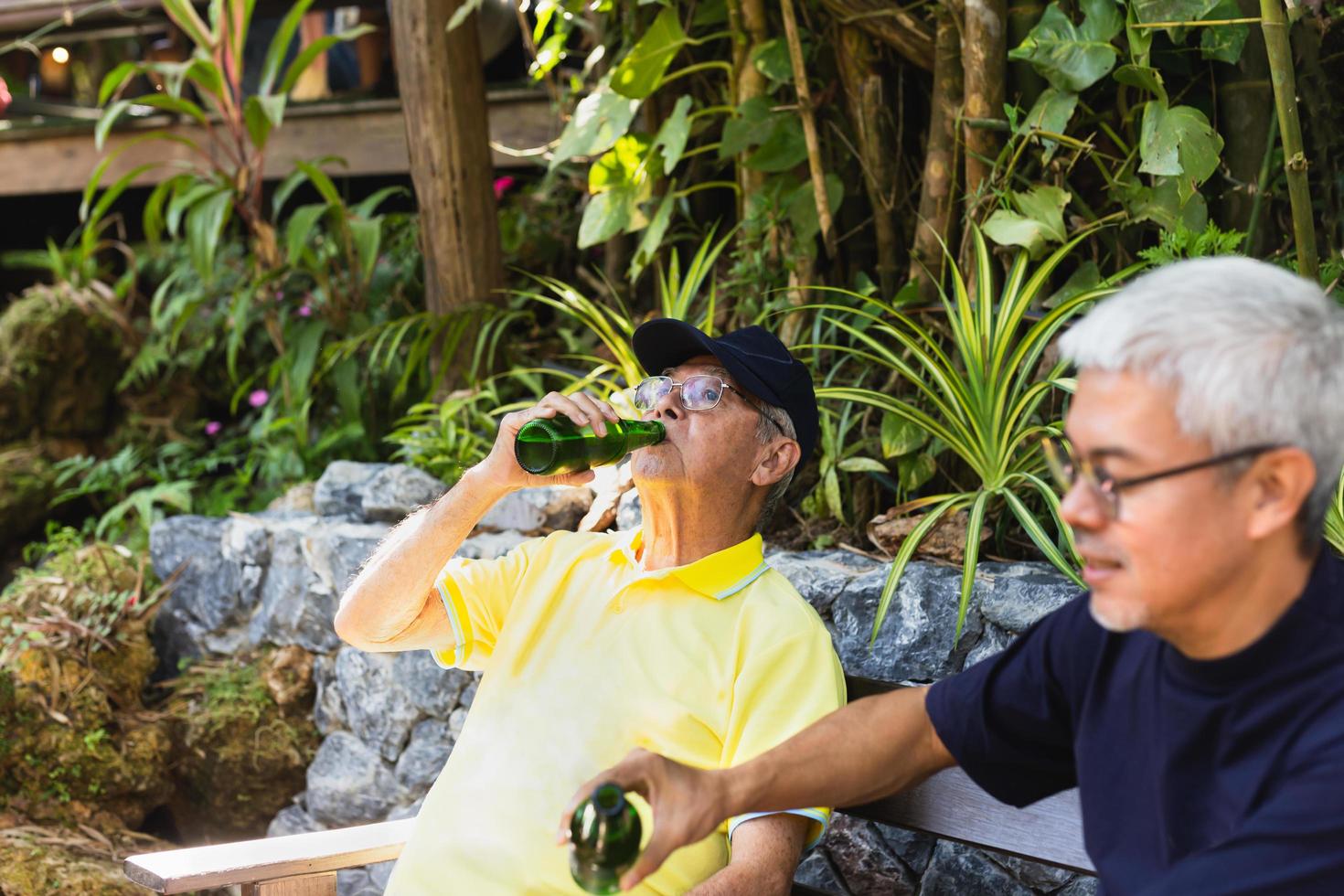 vader en zoon zittend in stoelen en drinken bier Aan vakantie. foto