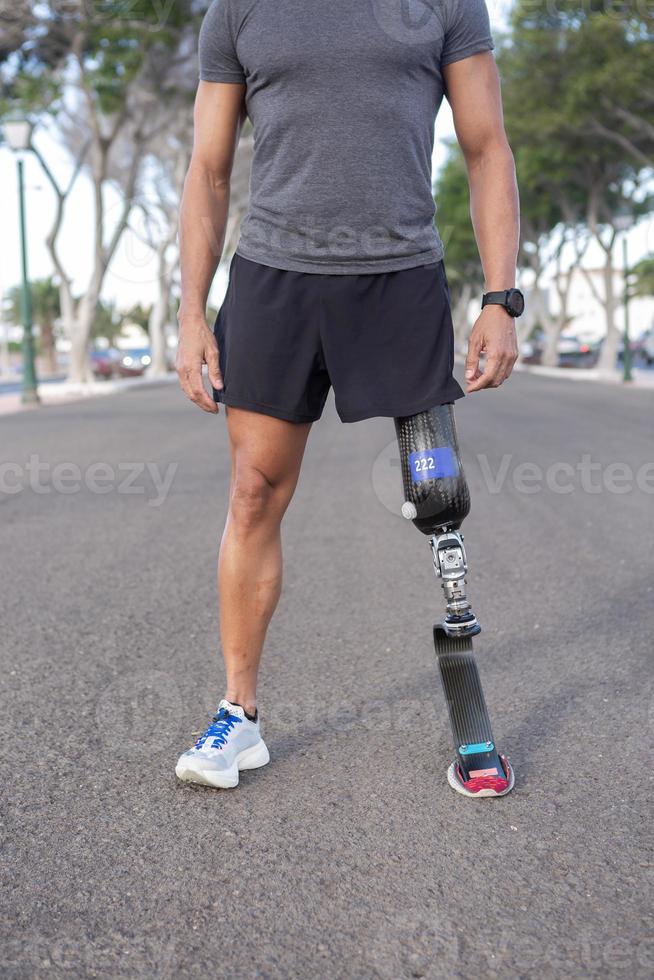 Bijsnijden sportman met been prothese staand Aan straat foto