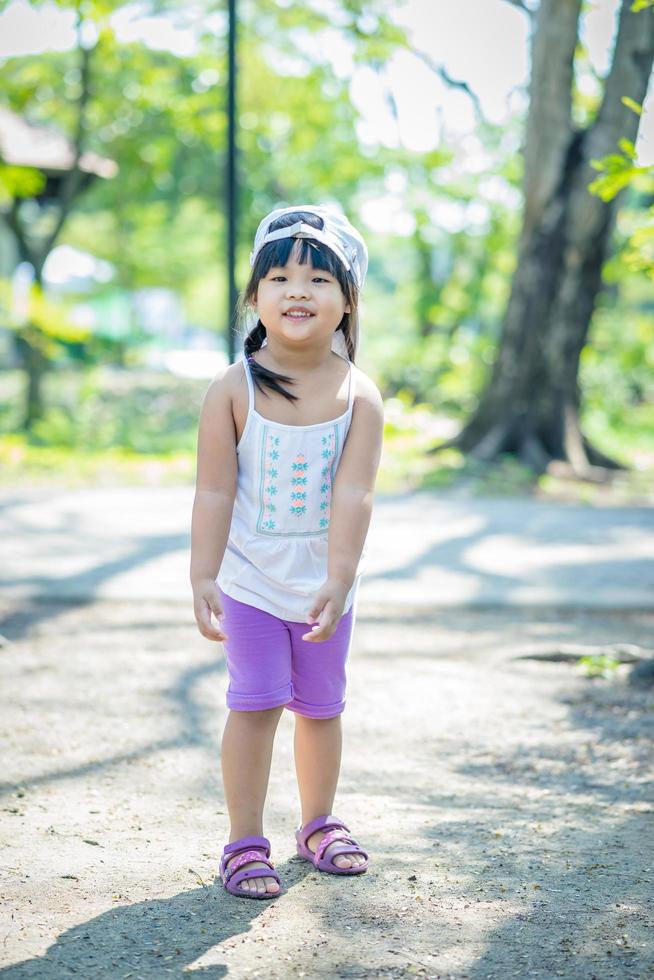 portret van een klein meisje draagt een hoed wandelen in het park foto