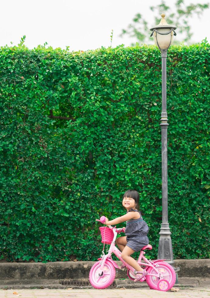 gelukkig klein meisje fietsen in het park foto