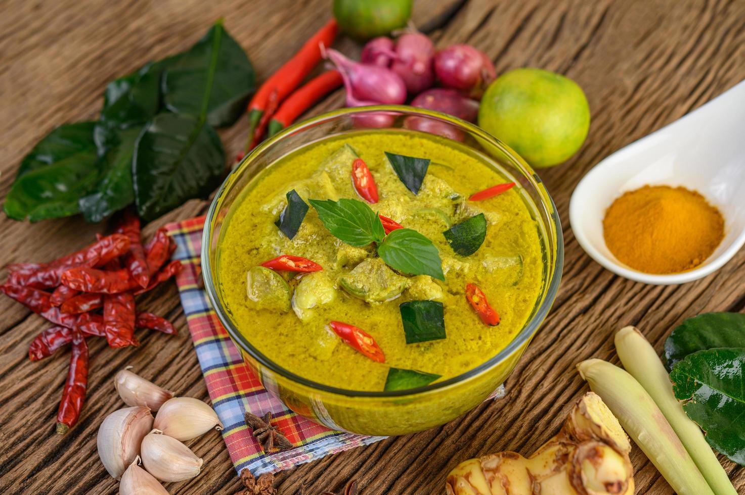 pittige groene curry in een kom met kruiden foto