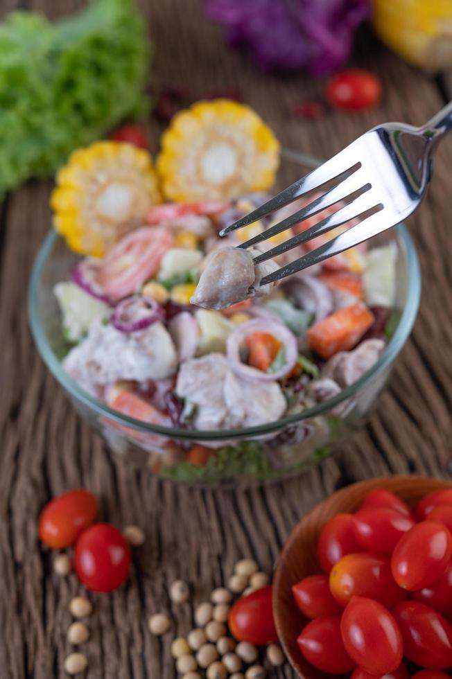 fruit- en groentesalade in een glazen kom op houten tafel foto