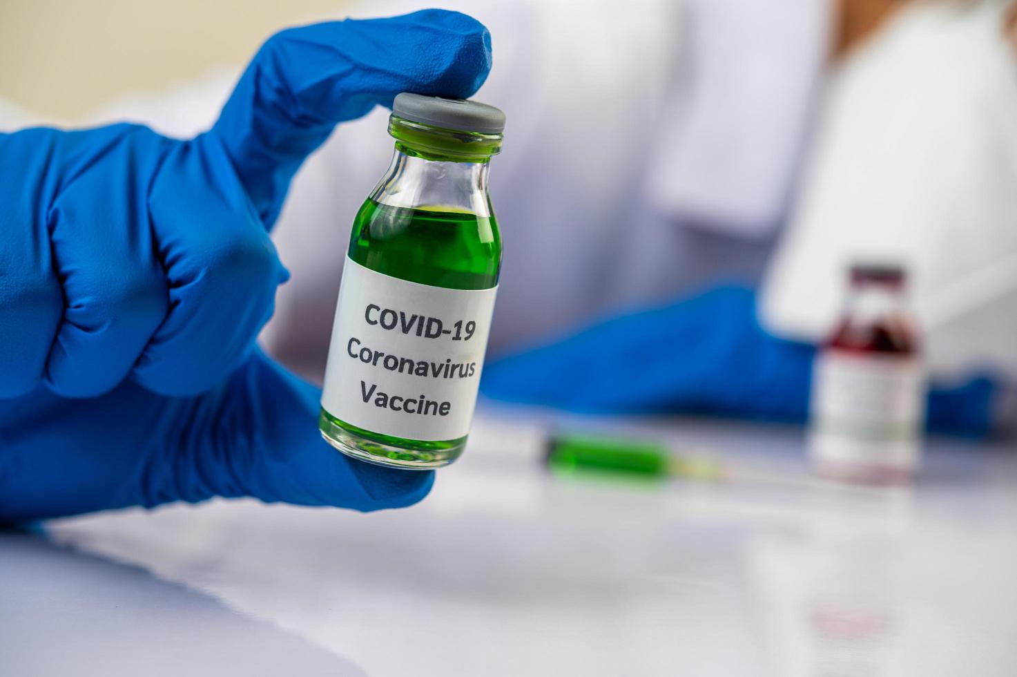 wetenschapper die flesjes met vaccins toont ter bescherming tegen covid-19 foto