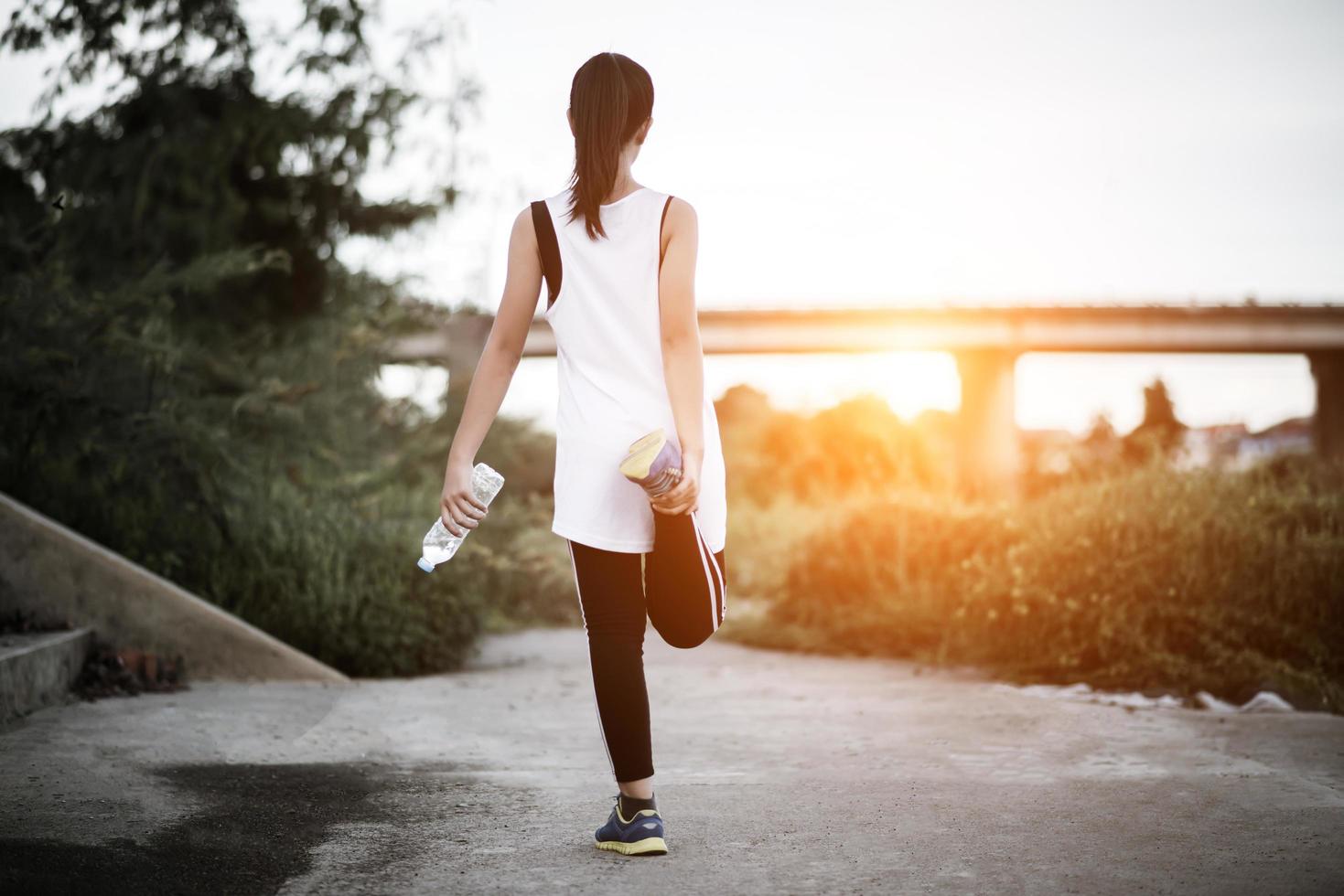 jonge fitness tiener bedrijf waterfles na het uitvoeren van oefening foto