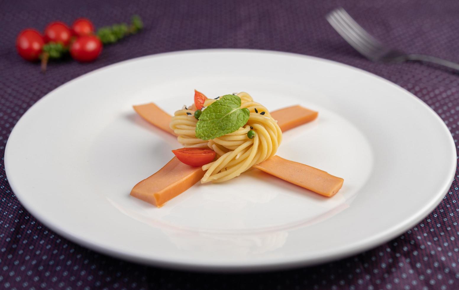 gastronomische spaghetti prachtig gerangschikt op een witte plaat foto