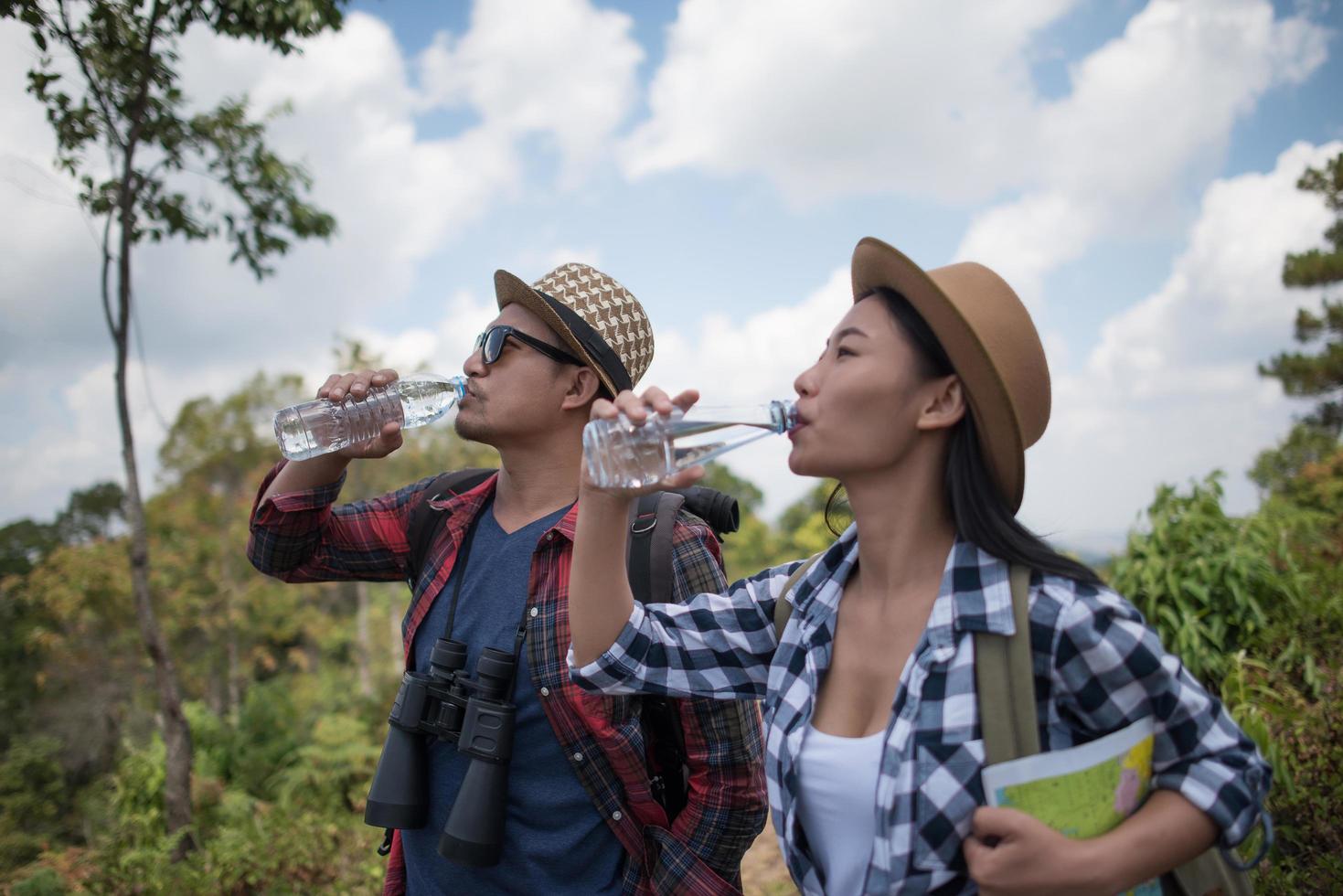 jonge wandelaars drinkwater in het bos foto