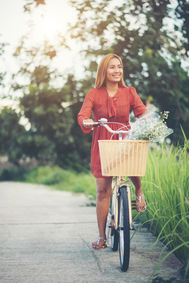 jonge Aziatische vrouw fietsen in een park foto