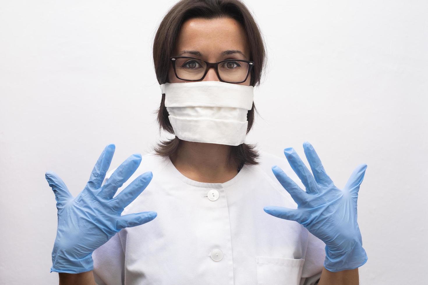 verpleegster die een masker en blauwe handschoenen draagt in het ziekenhuis foto