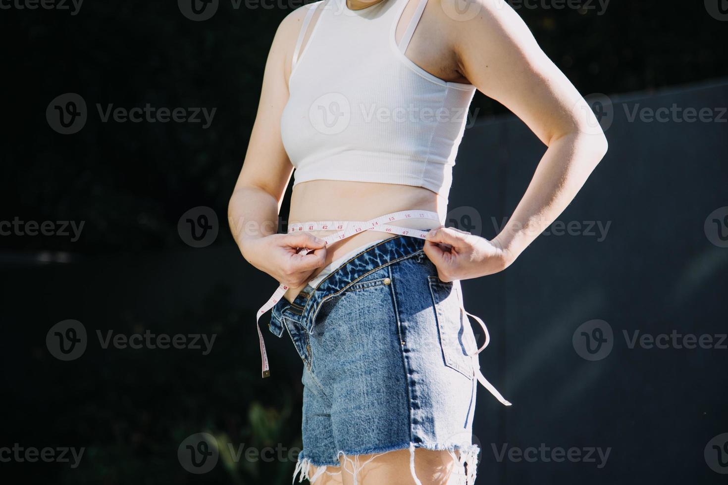 dik vrouw, dik buik, mollig, zwaarlijvig vrouw hand- Holding buitensporig buik dik met meten plakband, vrouw eetpatroon levensstijl concept foto