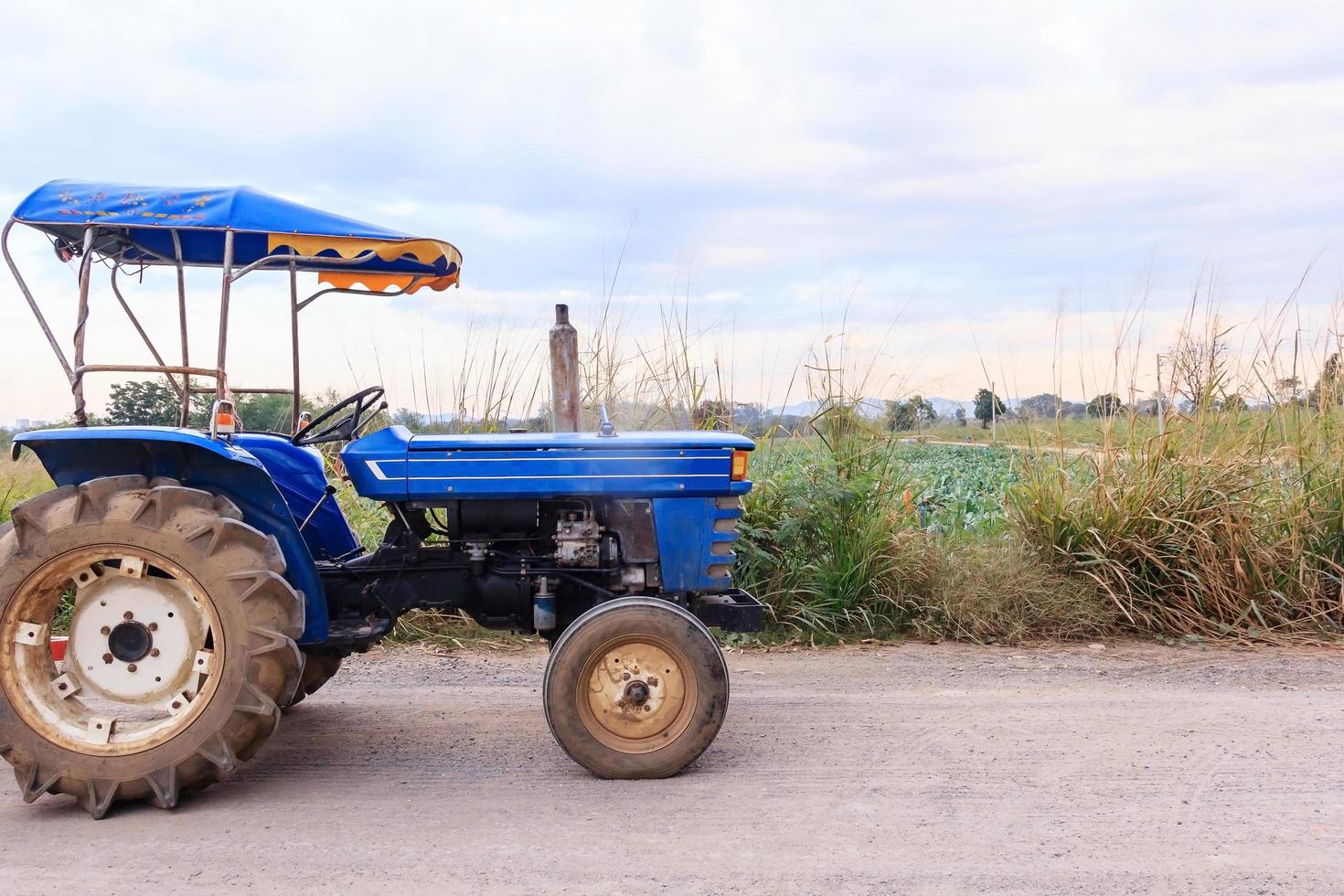 e-taen-voertuig of landbouwtractor op het platteland met een groen landschap van biologische groenteboerderijen, landbouwvoertuigen foto