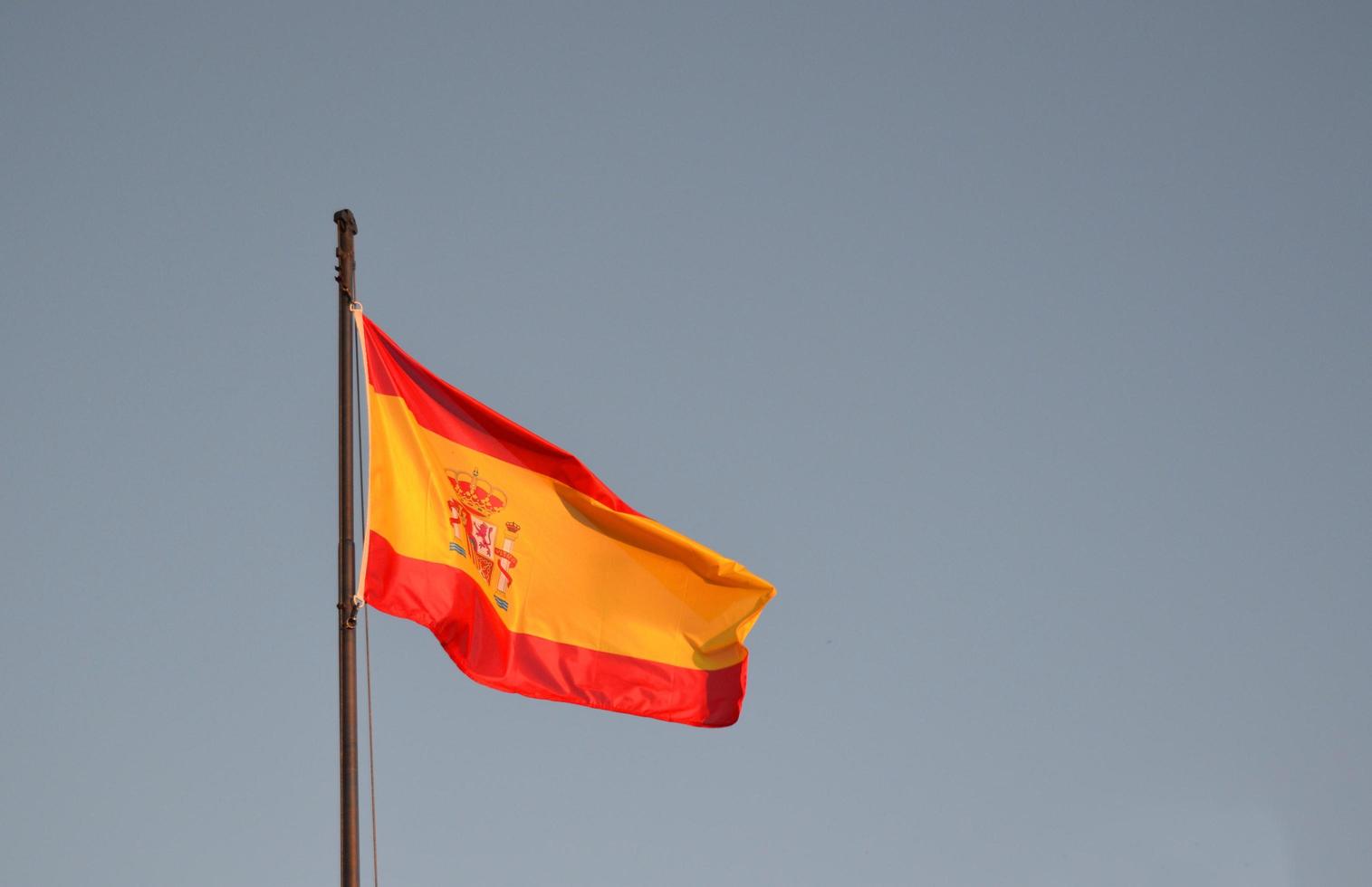 vlag van spanje met een blauwe hemel foto