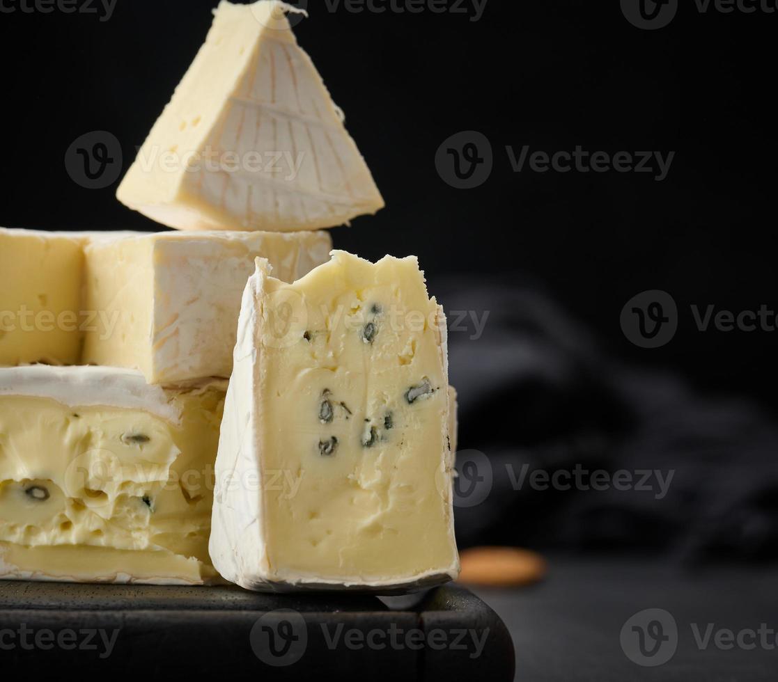 Brie en bergader blauw kaas Aan een bruin houten bord, heerlijk tussendoortje foto