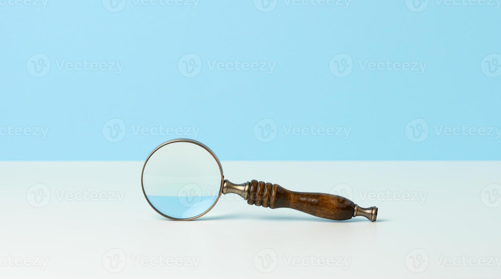 houten vergrootglas Aan een wit achtergrond. de concept van onzekerheid en de zoeken voor oplossingen, twijfels foto