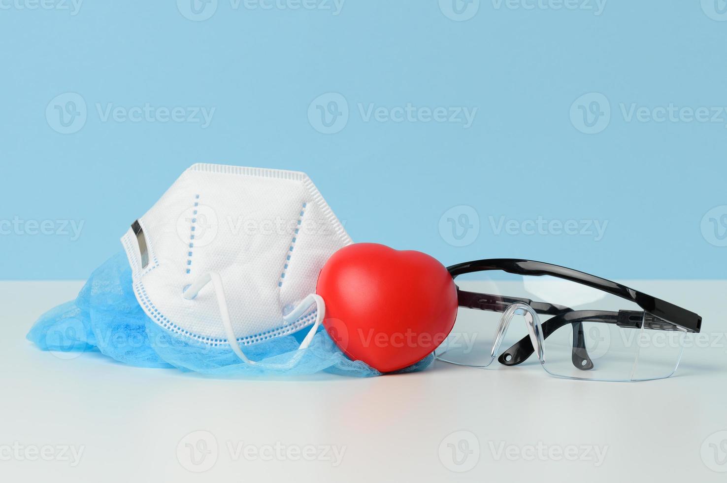 transparant plastic beschermend medisch bril en wit beschikbaar masker Aan een blauw achtergrond foto