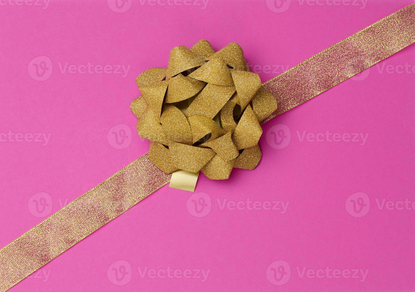 boog en gouden zijde lint Aan een roze achtergrond, ontwerp element voor geschenk decor, lijn foto