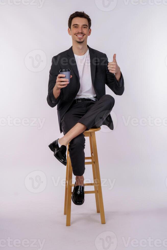 portret van gelukkig glimlachen jong zakenman tonen duimen omhoog gebaar en Holding koffie Aan geïsoleerd over- wit achtergrond foto