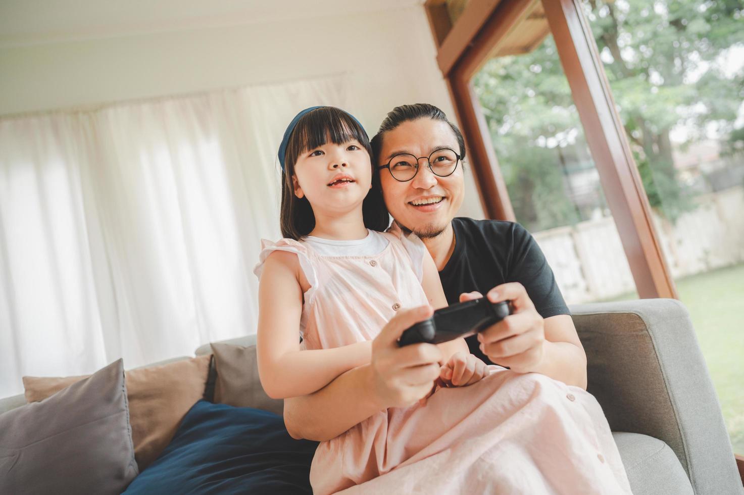 vader en dochter spelen van videogame foto