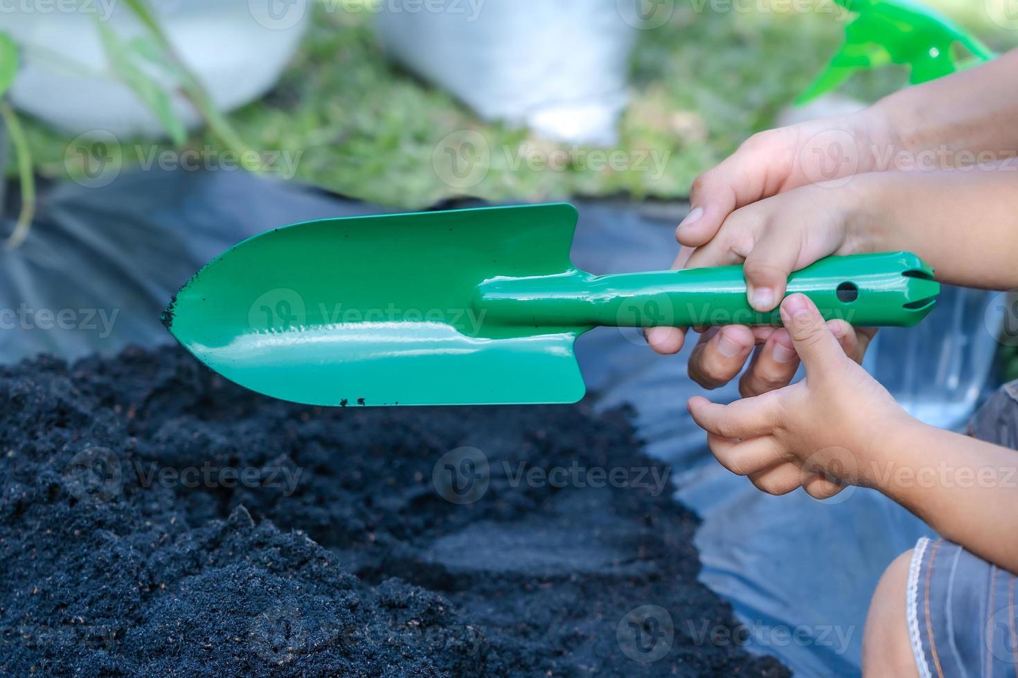 detailopname van kleuter zoon en moeder hand- onderwijs weinig zoon voorbereidingen treffen bodem naar fabriek in tuin, moeder en zoon relatie. mama's weinig helper. tuinieren. vrije tijd activiteiten concept foto