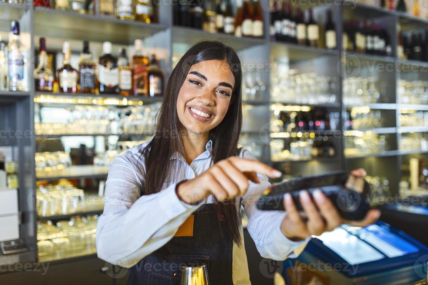 contactloos betaling concept, vrouw Holding terminal nfc technologie Aan balie, cliënt maken transactie betalen Bill Aan terminal rfid Kassa machine in restaurant op te slaan, dichtbij omhoog visie foto