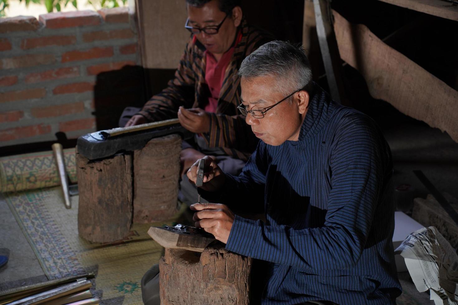 keris ambachtslieden zijn onderwijs bezoekers over de werkwijze van maken keris in de werkplaats. bantul, Indonesië - 25 augustus 2022 foto