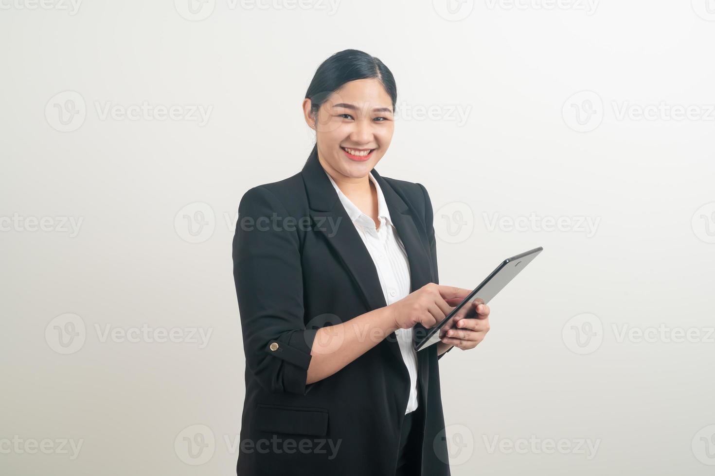 Aziatische vrouw die tablet met witte achtergrond vasthoudt en gebruikt foto