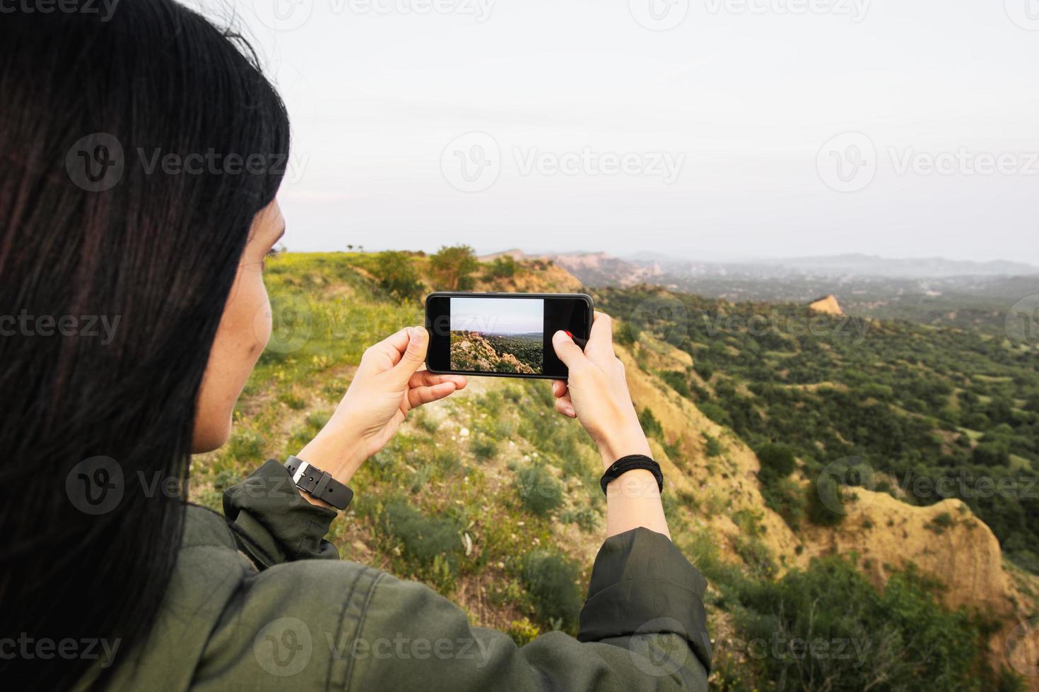 vrouw personen handen zijn Holding de smartphone en nemen foto van mooi natuur landschap Aan tour in de omgeving van vashlovani nationaal park. smartphone fotografie en gebruik makend van rooster mode